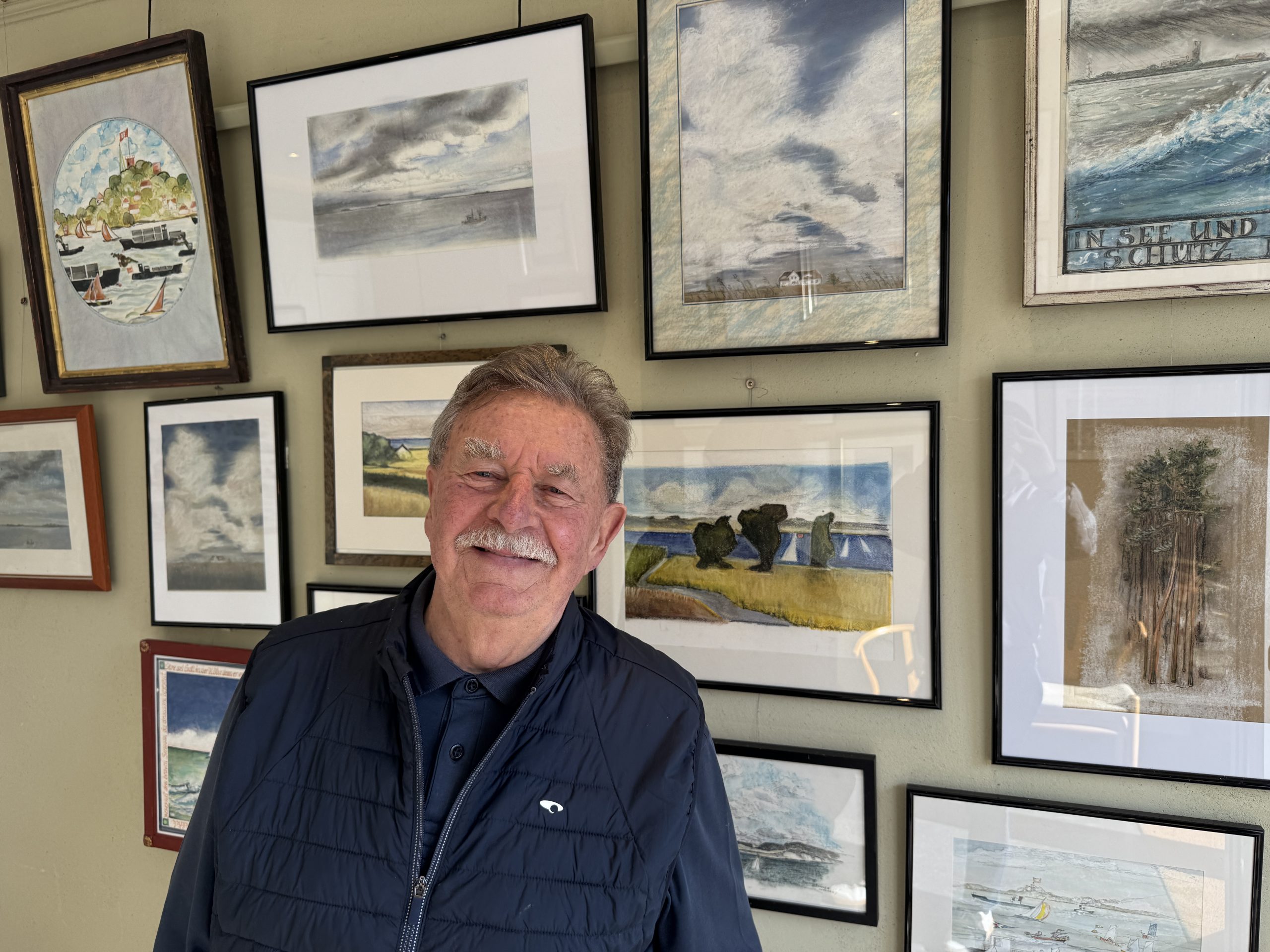 Bernd Dammann vor verschiedenen seiner Bilder