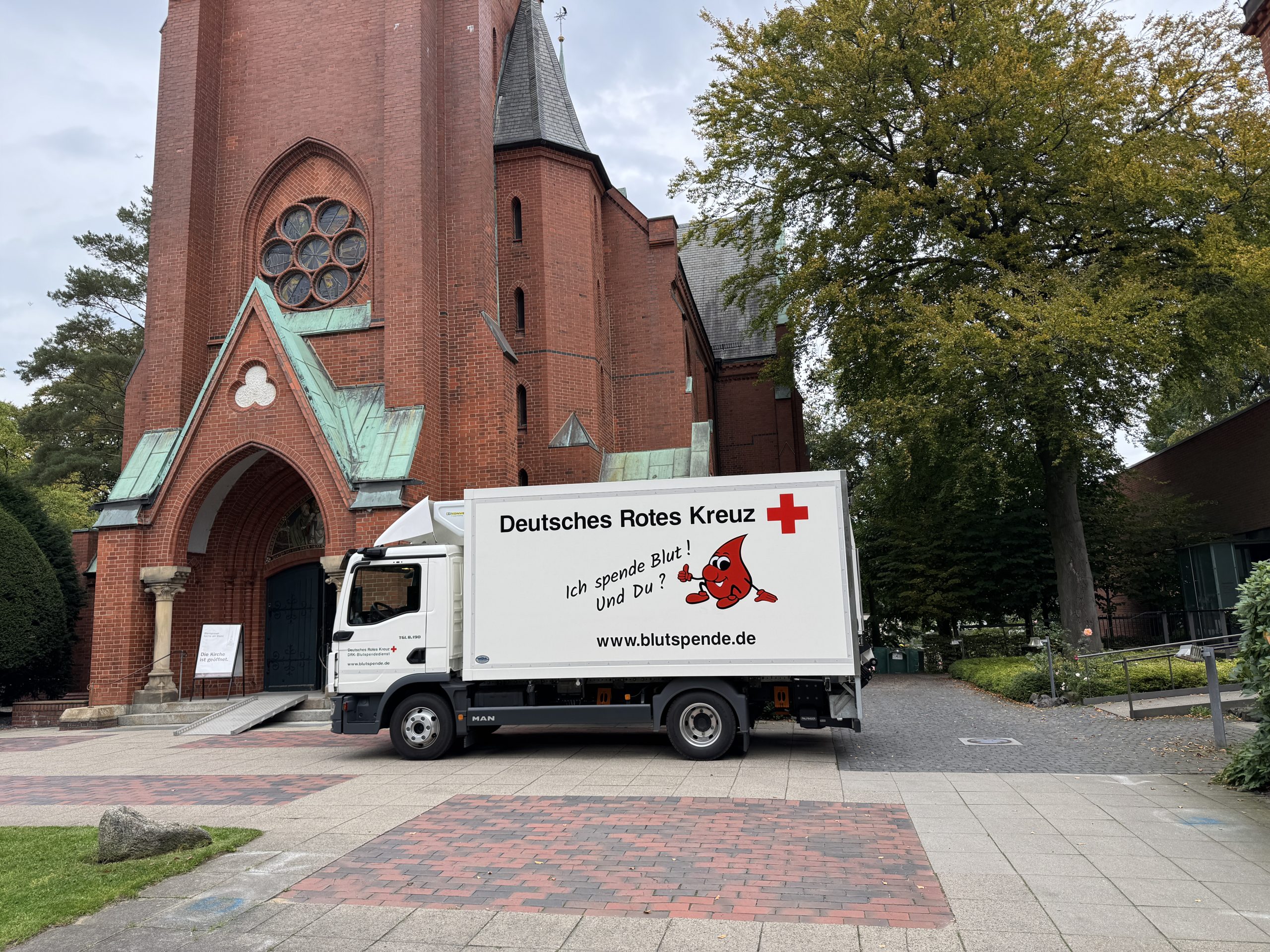 Ein LKW des DRK Blutspendedienstes steht vor der Blankeneser Kirche.